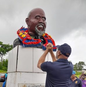 President General of the OWTU Ancel Roget lays a wreath at the grave of Tubal Uriah 'Buzz' Butler. AZP News/Sue-Ann Wayow