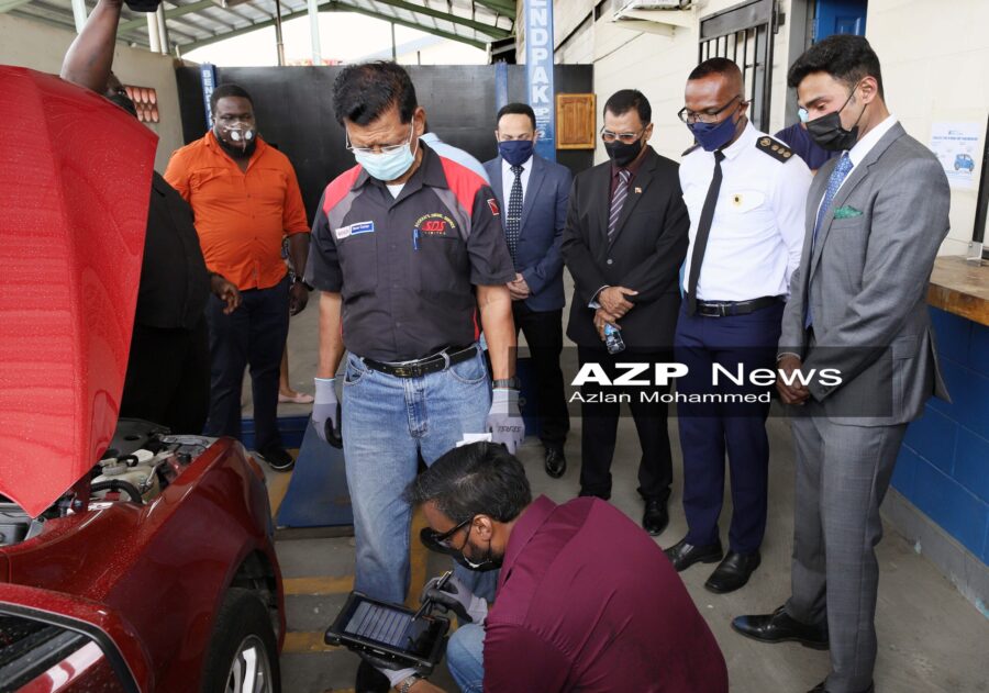 Inspectors Ronelle Sookhai, and Faizul Juman, standing, use the new electronic system on a vehicle as officials look on. AZP News/Azlan Mohammed