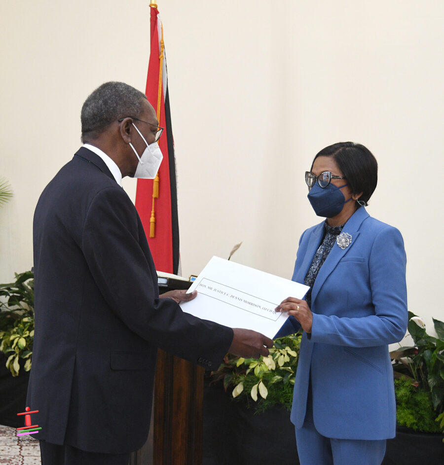 Acting President Christine Kangaloo presents chairman of the enquiry Justice Dennis Morrison with is instrument of appointment. Photo: Office of the President