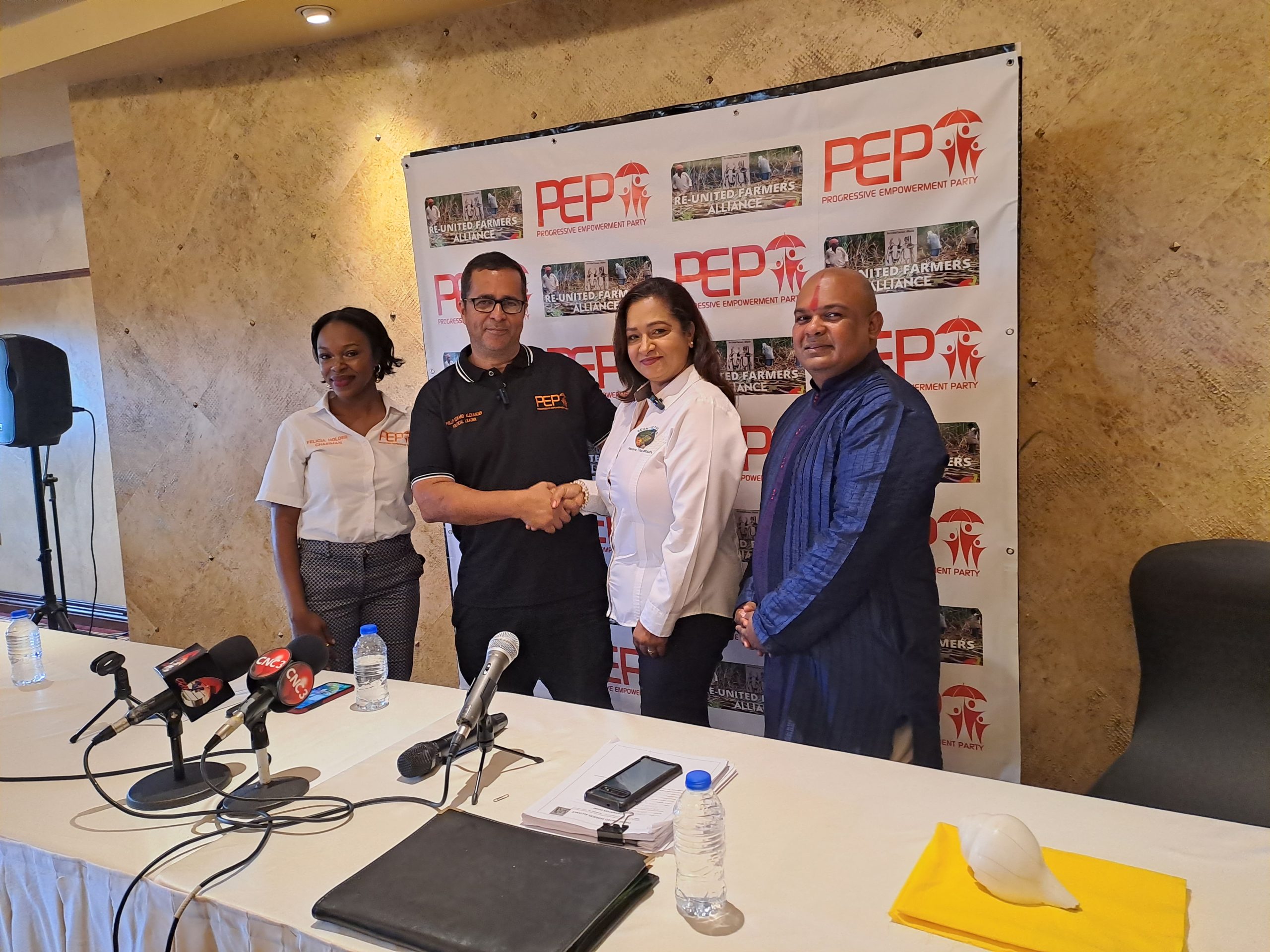 From left are PEP chairman Felicia Holder, PEP political leader Phillip Alexander shakes hands with Davica Thomas, of the Re-United Farmers and Pundit Donny Samlal. AZP News/Prior Beharry