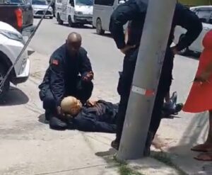 Screengrab of video showing security guard Hasley Augustine being assisted by a colleague