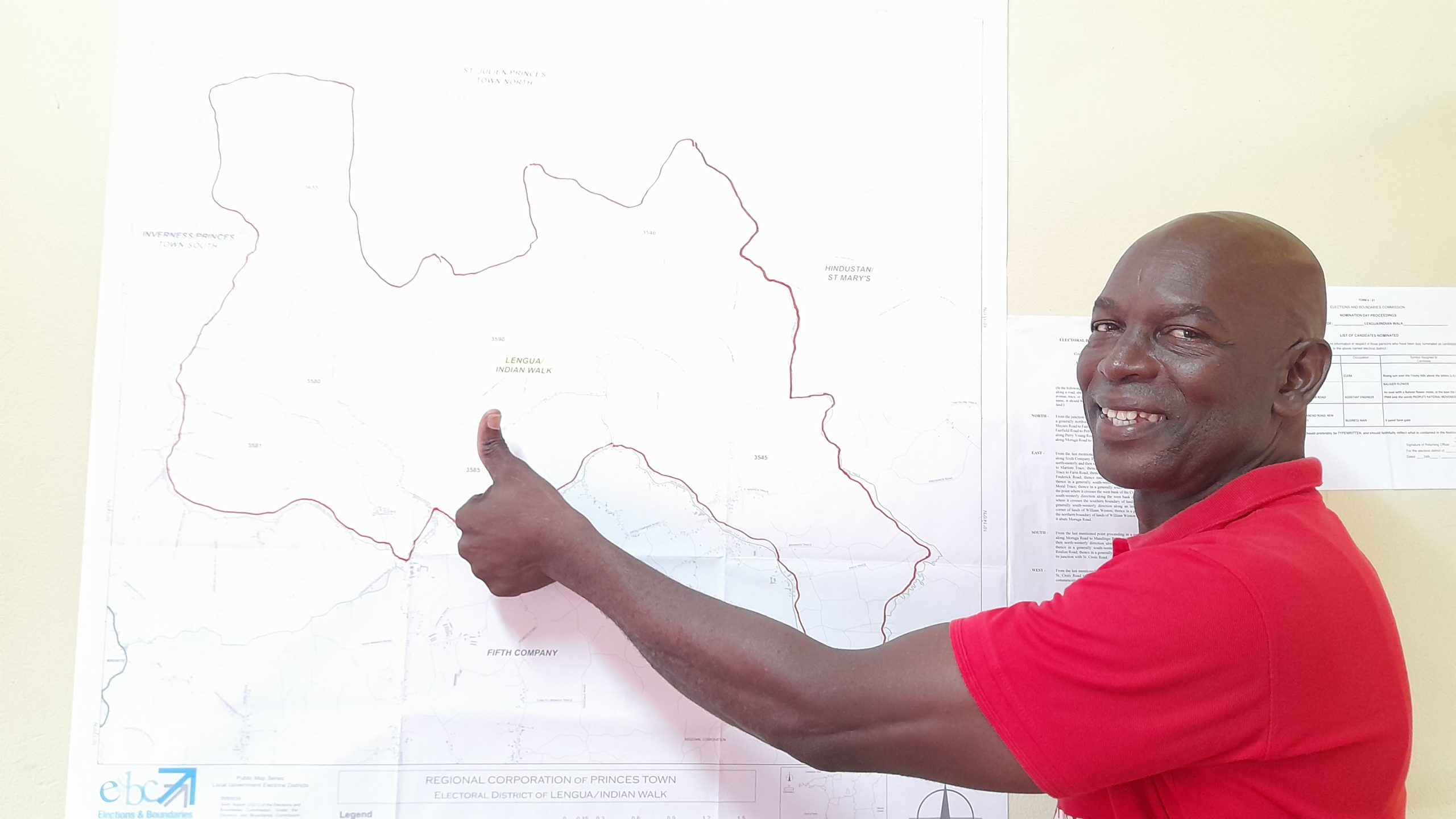 PNM candidate for Lengua/Indian Walk Autly Granthume gives a thumbs up in front of a map showing the Princes Town Regional Corporation at his campaign office at Indian Walk. AZP News/Sue-Ann Wayow