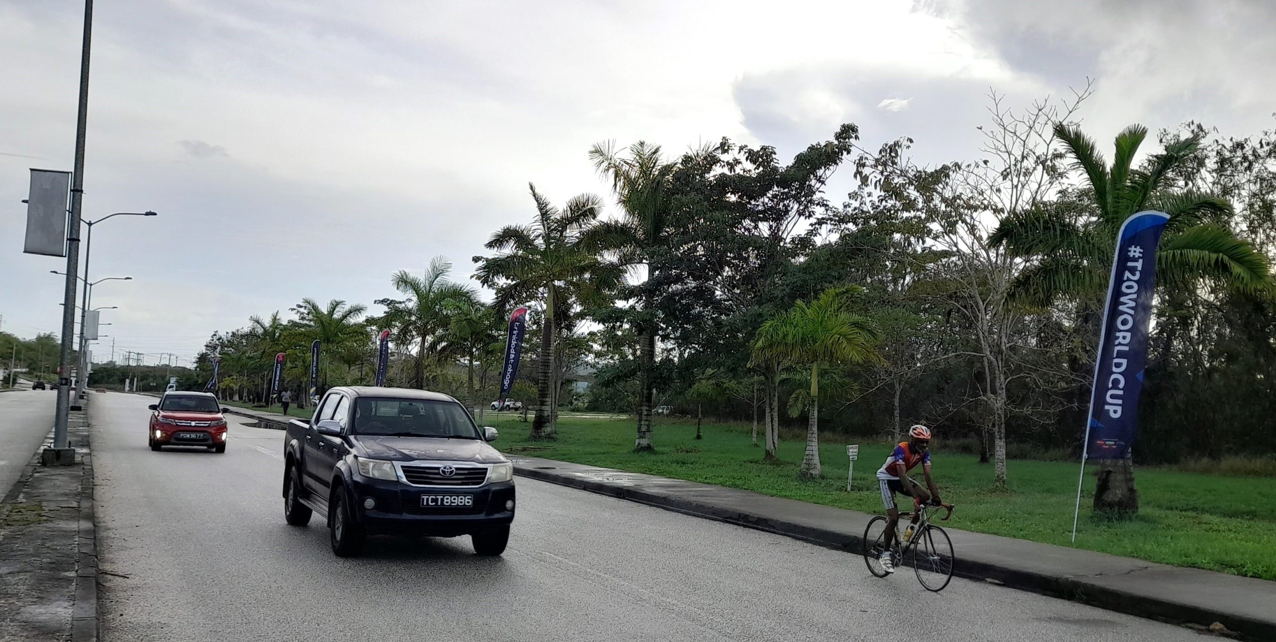 A cyclist rides past a sign promoting the ICC T20 World Cup hear to the Brian Lara Cricket Academy on Tuesday. AZP News/Sue-Ann Wayow