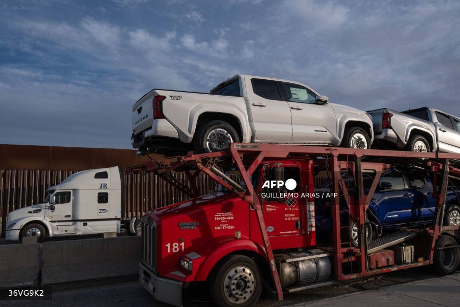 Caption: A car carrier trailer waits in line next to the border wall before crossing to the United States at Otay commercial port in Tijuana, Baja California state, Mexico, on January 22, 2025. US President Donald Trump has threatened to slap a 25-percent tariff on Mexican goods on February 1, a move that analysts say would deal a heavy blow to Latin America's second-largest economy. AFP/Guillermo Arias