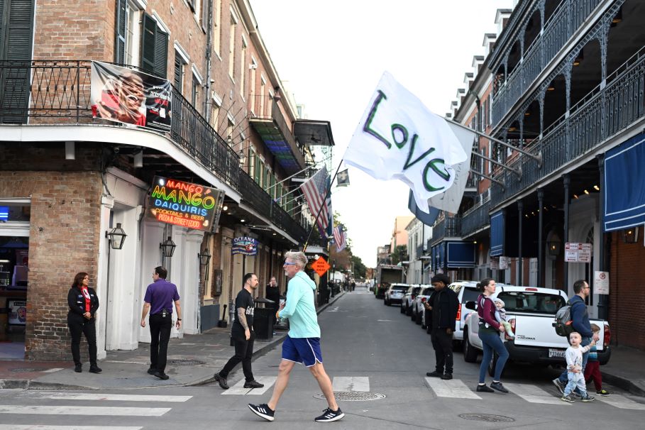 A man runs with a love flag down Bourbon Street in New Orleans, Louisiana, the day after an attack by a man driving a truck down Bourbon street in the French Quarter. AFP/Andrew Caballero-Reynolds