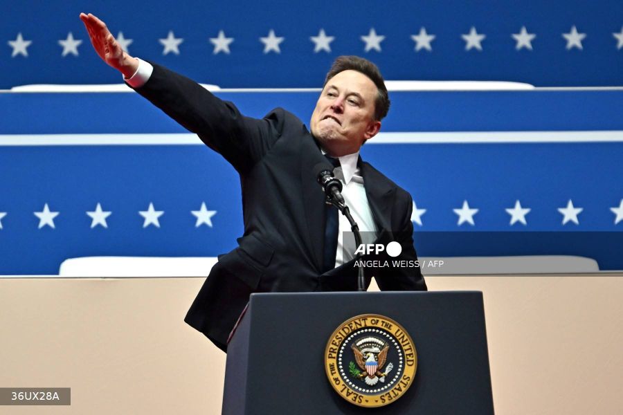 Caption: Tesla and SpaceX CEO Elon Musk gestures as he speaks during the inaugural parade inside Capitol One Arena, in Washington, DC, on January 20, 2025. AFP/Angela Weiss
