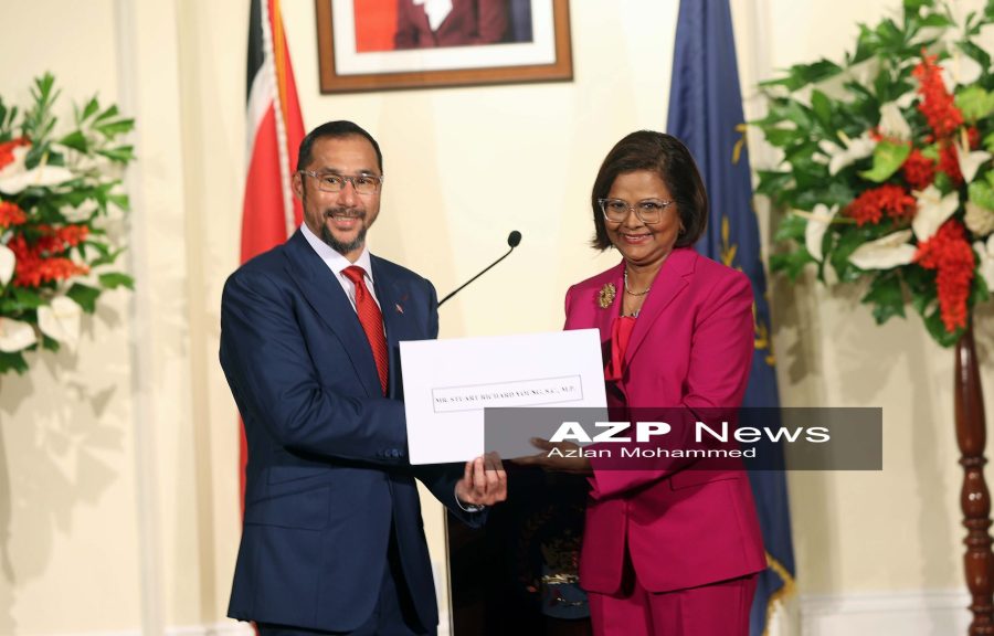 Caption: President Christine Kangaloo presents newly-appointed Prime Minister Stuart Young with his instruments of appointment.