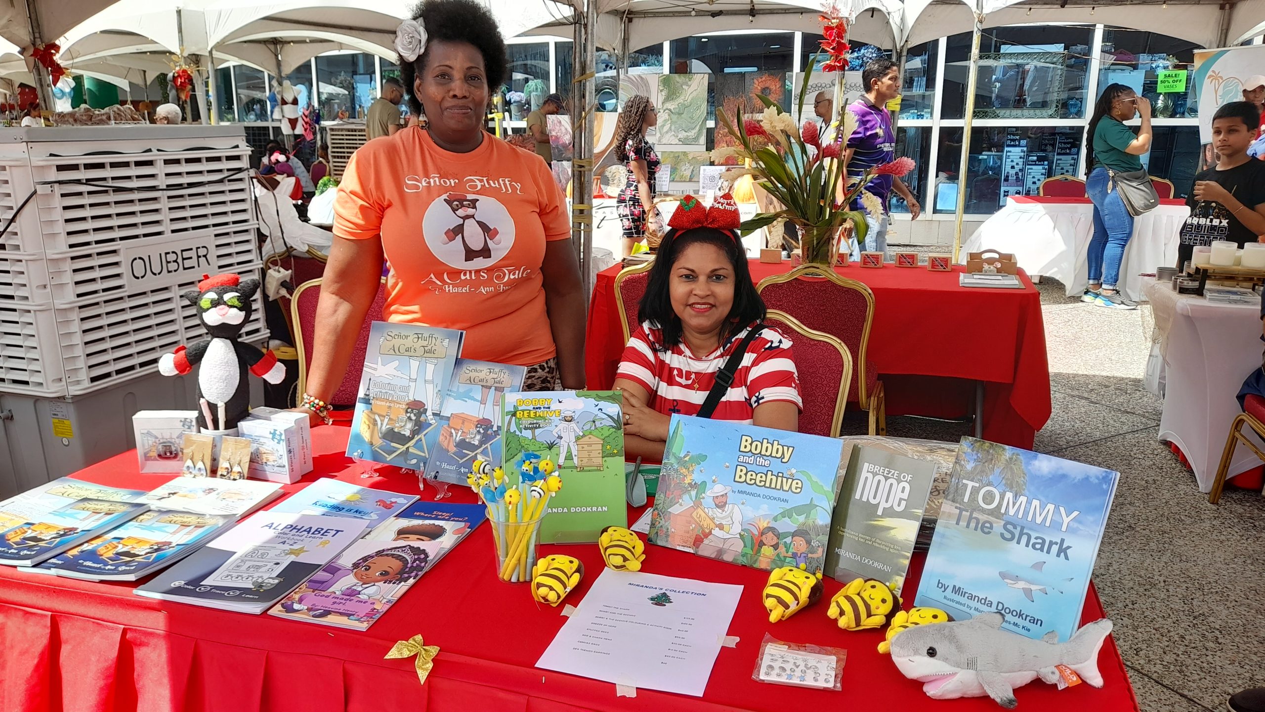 Caption: Author Miranda Dookran, right, and author Hazel-Ann Lynch displaying their books at the National Entrepreneurship Development Company Ltd (NEDCO) Christmas event at C3 Centre last December. AZP News/Sue-Ann Wayow