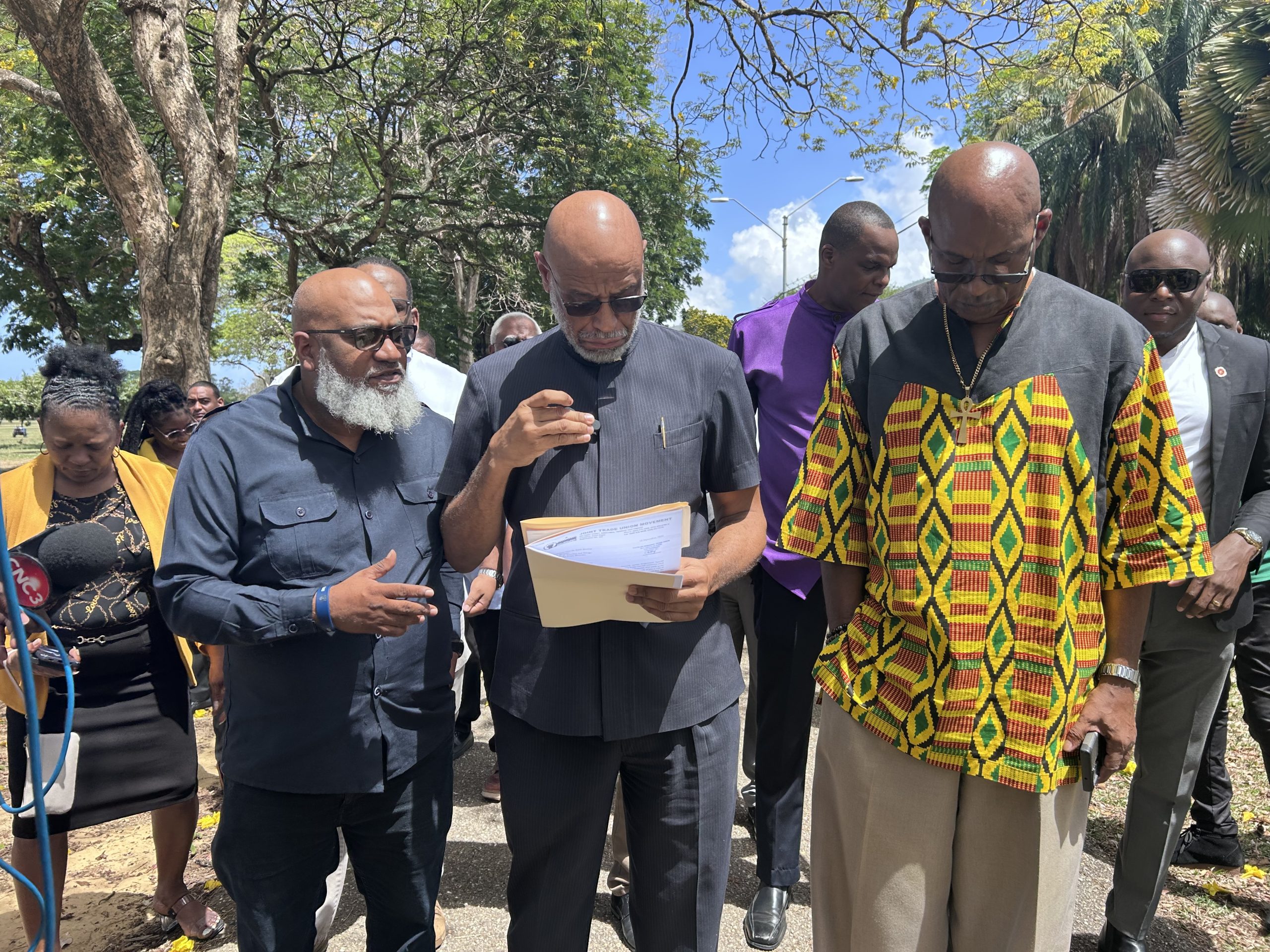 From left General Secretary of the Joint Trade Union Movement Ozzy Warwick, JTUM President Ancil Roget and National Trade Union Centre General Secretary Michael Annissette gather with 11 other union heads outside of the President's House on Monday to demand the contractual extension of Industrial Court Chairman Larry Achong be rescinded. AZP News/Alicia Chamely
