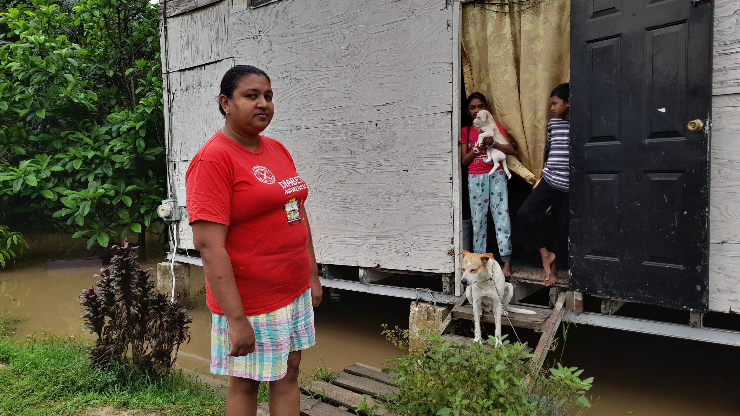 Caption: Vindra Mangroo at her flooded home along the banks of the Godineau River on Thursday. AZP News/Sue-Ann Wayow