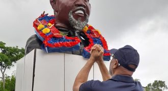 President General of the OWTU Ancel Roget lays a wreath at the grave of Tubal Uriah 'Buzz' Butler. AZP News/Sue-Ann Wayow