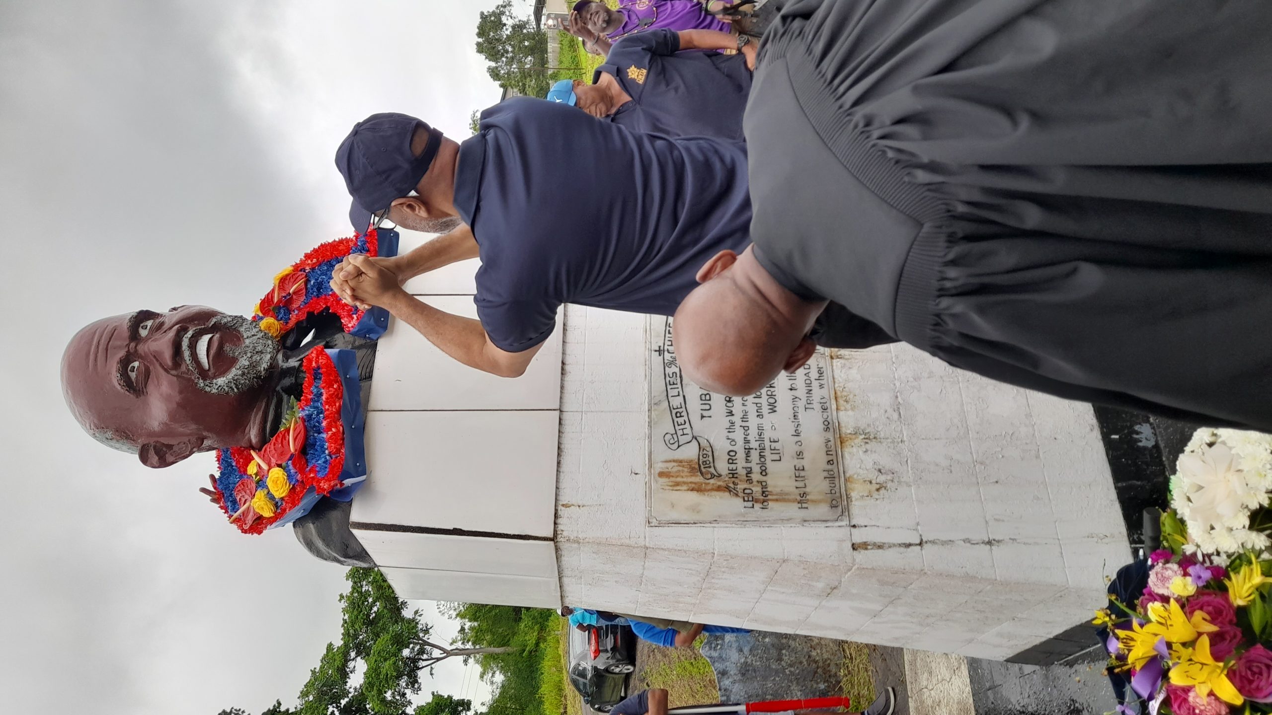 President General of the OWTU Ancel Roget lays a wreath at the grave of Tubal Uriah 'Buzz' Butler. AZP News/Sue-Ann Wayow