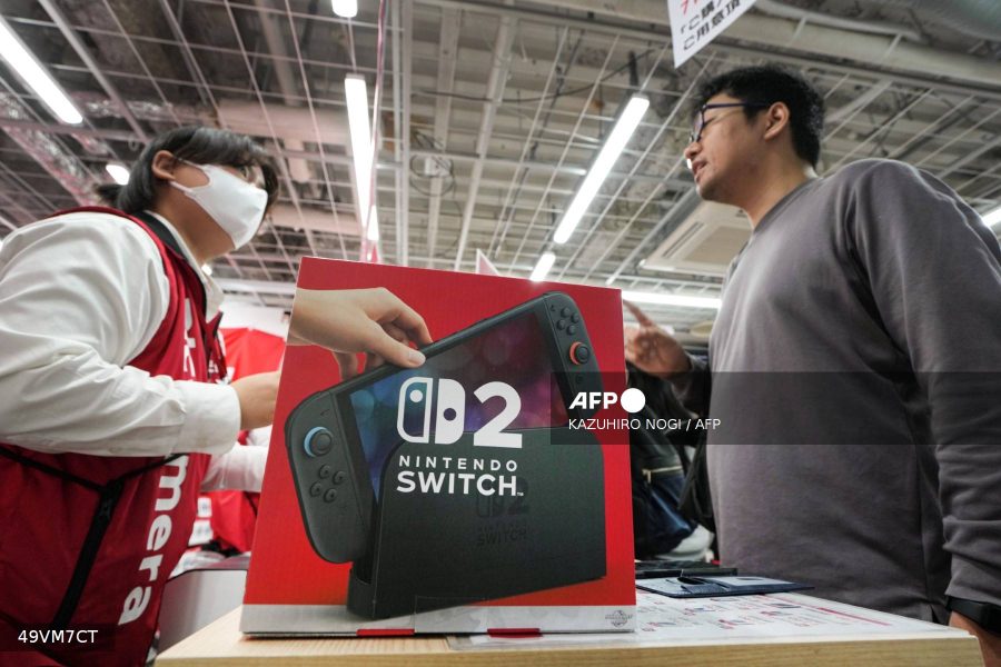 Caption: This file photo taken on June 5, 2025 shows a customer (R) purchasing a Nintendo Switch 2 at an electronics retailer in Tokyo. Nintendo said on June 11, 2025 it had sold a record 3.5 million Switch 2 units worldwide in the first four days after the console was launched
