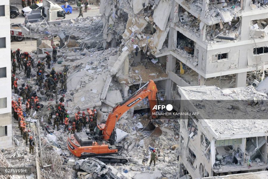 Israeli rescuers search through the rubble at the site of an overnight Iranian missile strike in Bat Yam