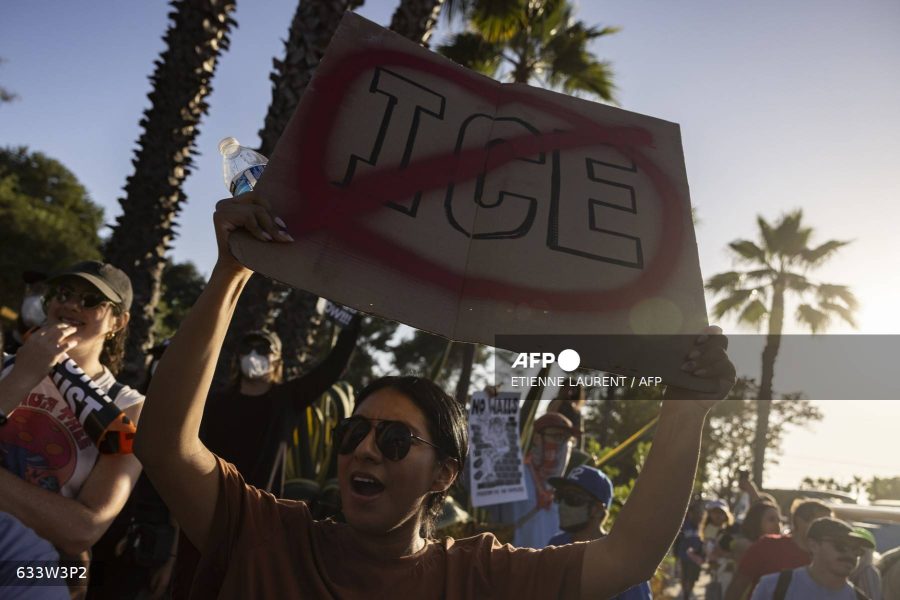 Caption: A demonstrator holds up a sign as they protest in front of the main entrance of Dodger Stadium to call for a boycott of the team, claiming the organisation supports federal immigration efforts, in Los Angeles, on June 19, 2025