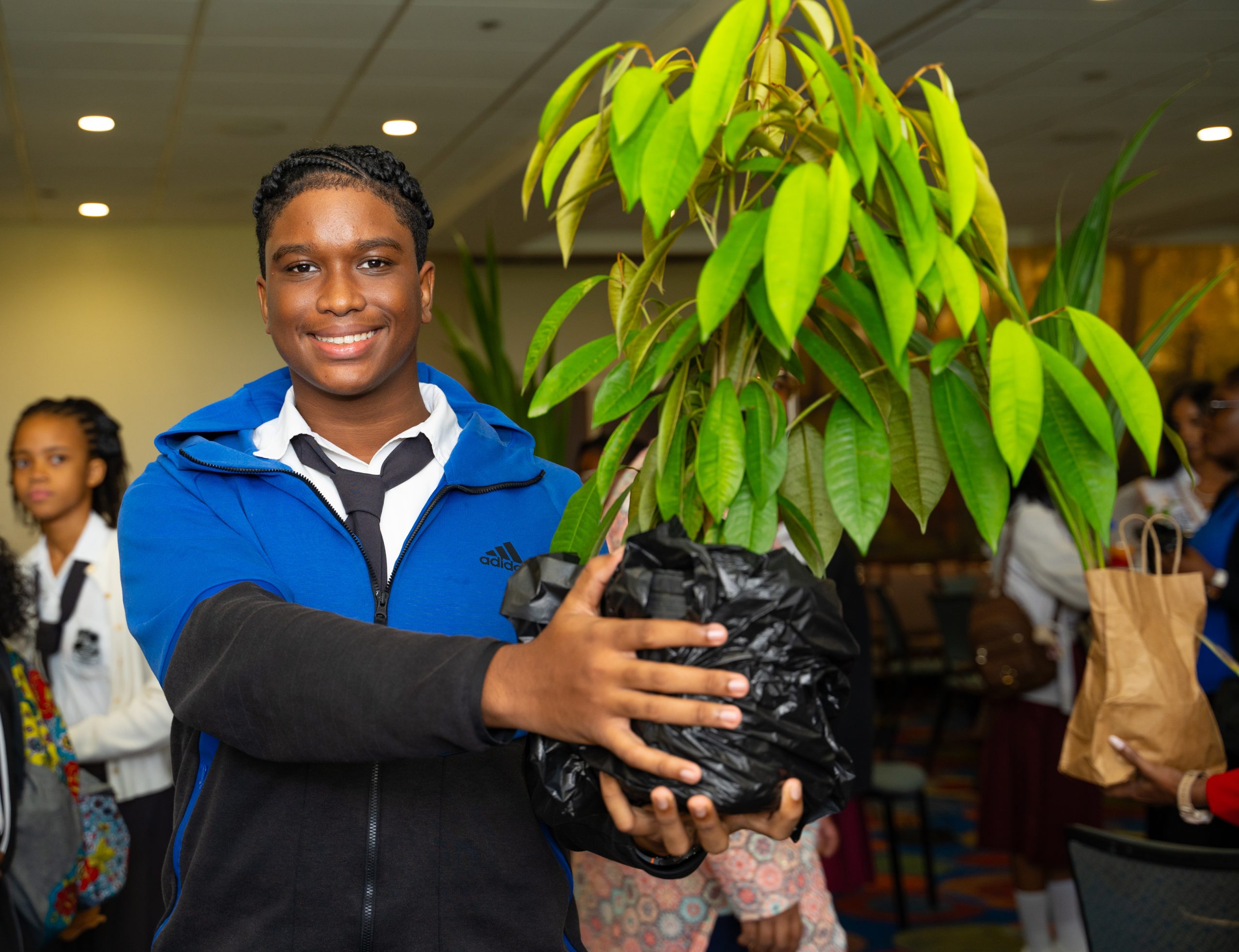 Caption: Christian Barker, a student at Marabella South Secondary shows off the star apple tree he will plant on his school compound, at Monday's launch of the Heroes Foundation Leaves of Legacy at the Hilton Trinidad Hotel and Conference Centre. 