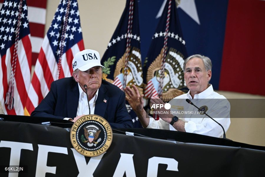 US President Donald Trump (L) listens to Texas Governor Greg Abbott speak during a meeting with local officials and first responders in Kerrville, Texas, on July 11, 2025, following devastating flooding that ocurred in the area over the July 4 weekend. At least 120 people are dead and more than 170 still missing, following July 4 holiday weekend floods that ravaged the central Texas Hill Country -- including a river bank cluttered with children's summer camp cabins. (Photo by Brendan SMIALOWSKI / AFP)