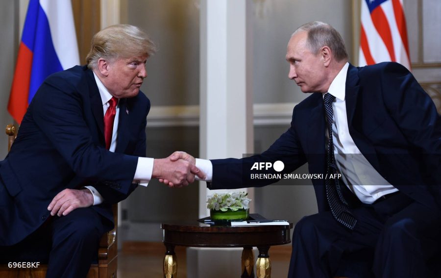 Caption:  Russian President Vladimir Putin, right, and US President Donald Trump shake hands before a meeting in Helsinki on July 16, 2018