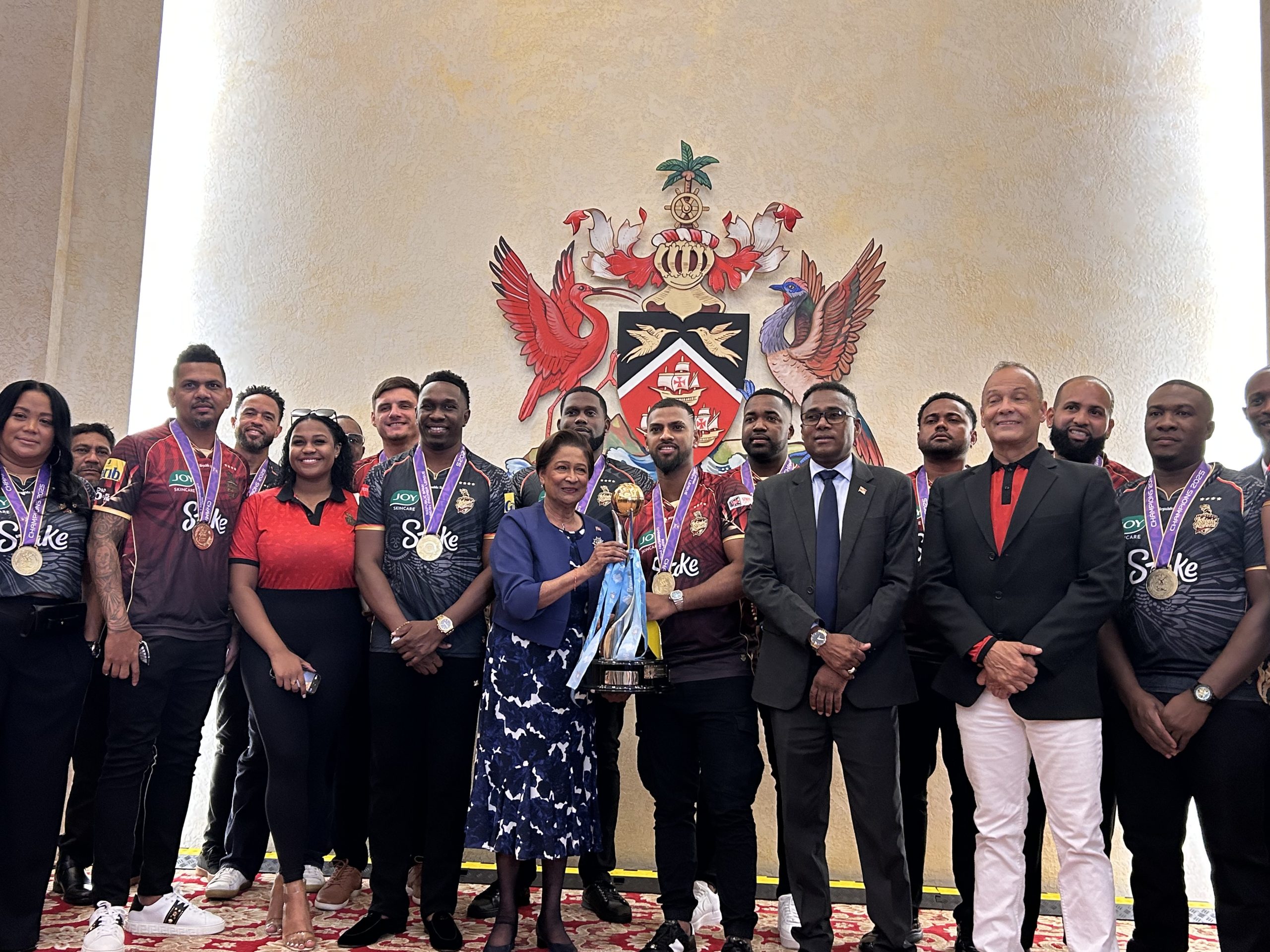 Prime Minister Kamla Persad-Bissessar holds the CPL trophy with the TRK team. AZP News/Alicia Chamely