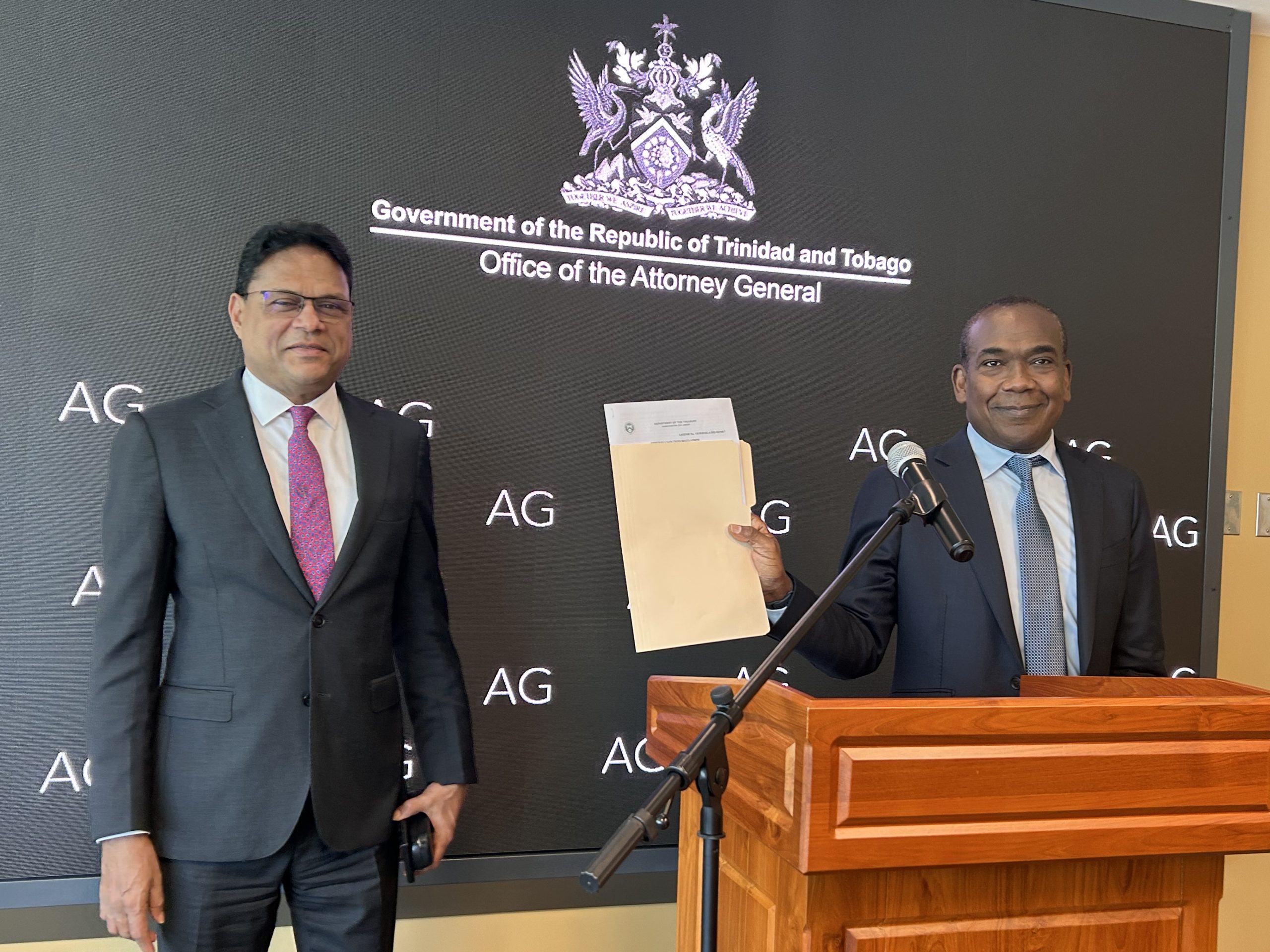 Caption: Attorney General John Jeremine holds the OFAC license issued by the US Treasury Department. He is joined by Minister of Justice Devesh Maharaj.   Photo: Alicia Chamely