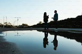 Two people talking reflected in a large ...