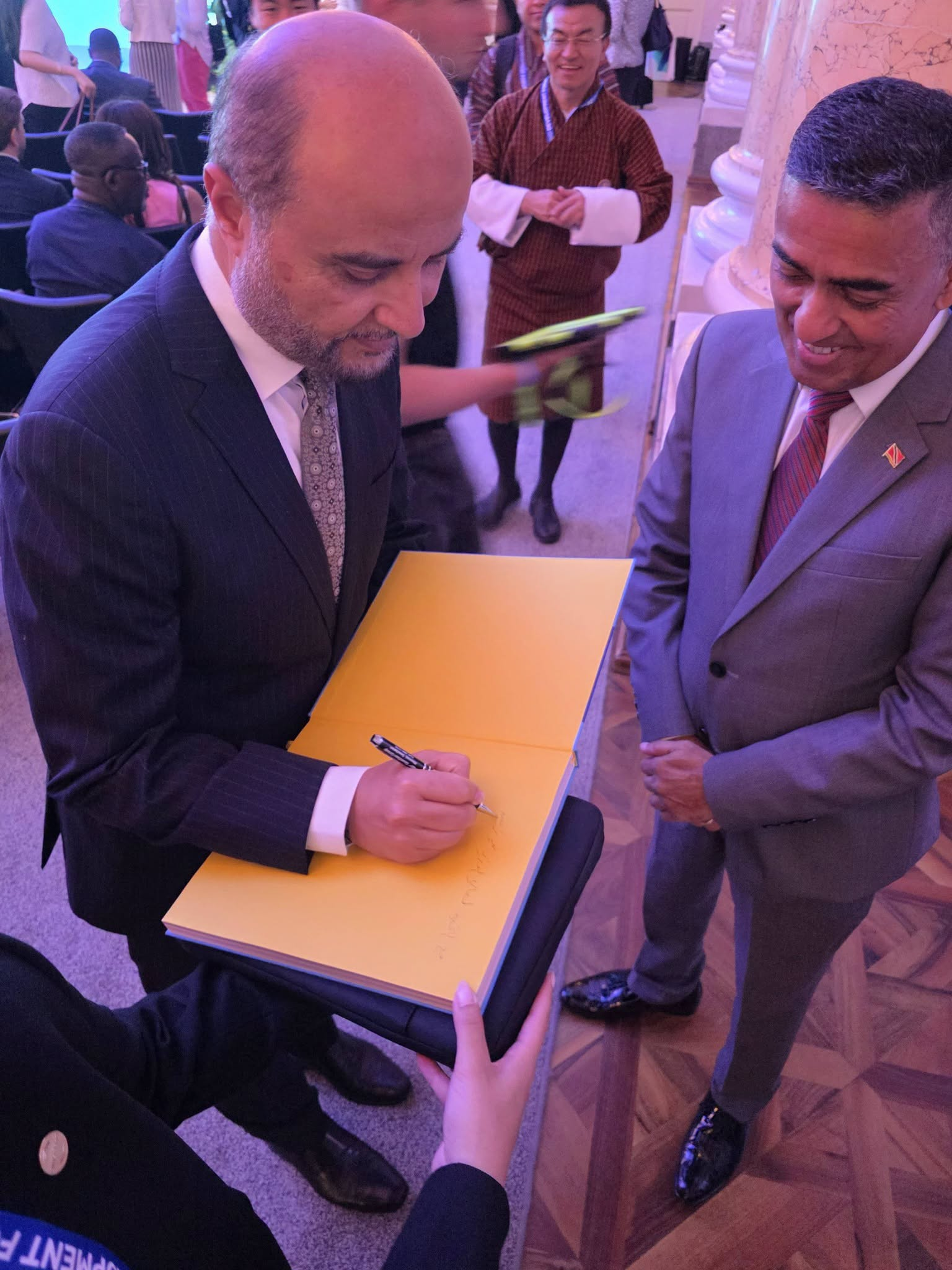 President of the OPEC Fund for International Development Dr Abdulhamid Alkhalifa writes greetings in Finance Minister Davendranath Tancoo's copy of the OPEC Fund's 50th Anniversary commemorative book. Photo: Facebook/mpDaveTancoo